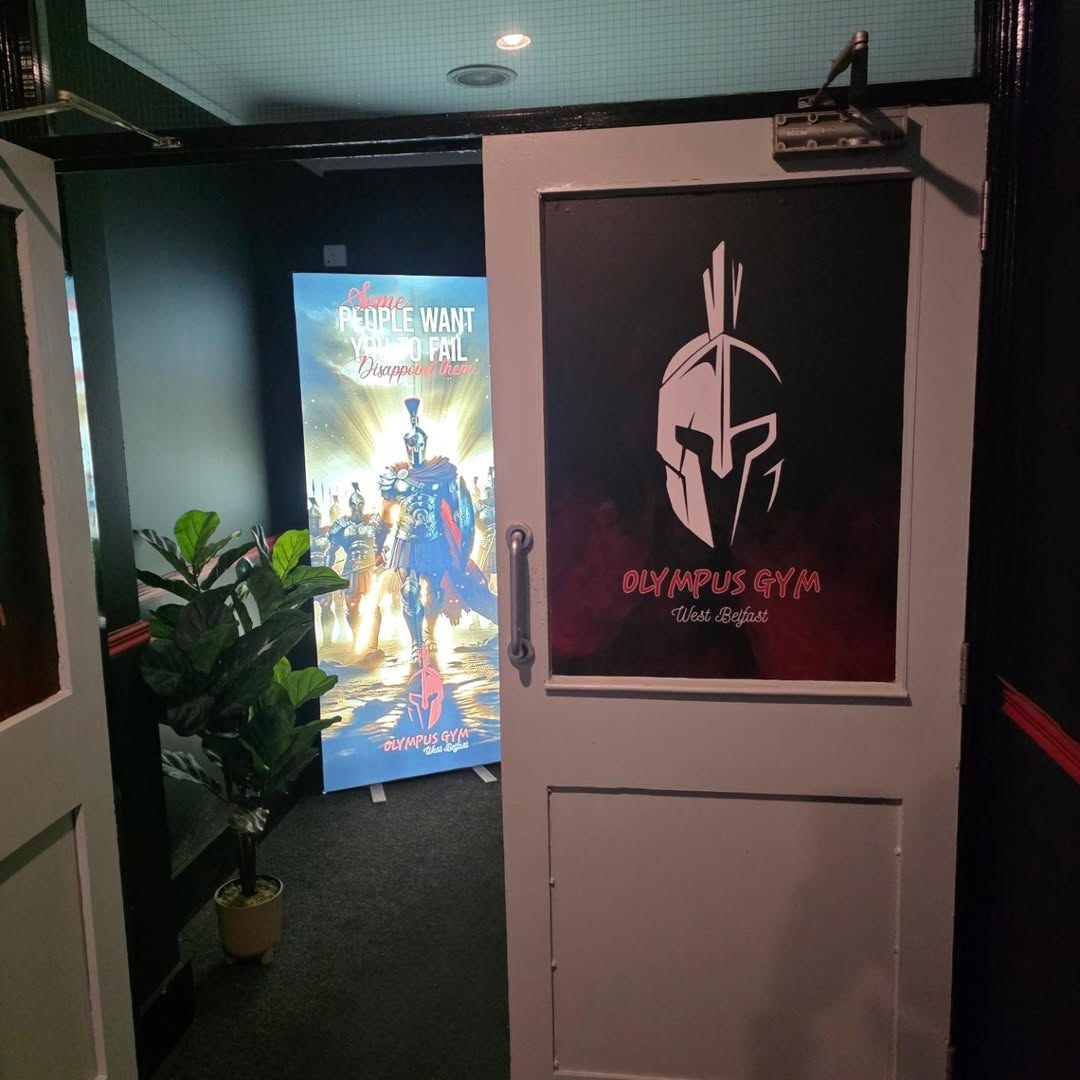 Inside the entrance: the door graphic, a plant and an Olympus pull-up banner