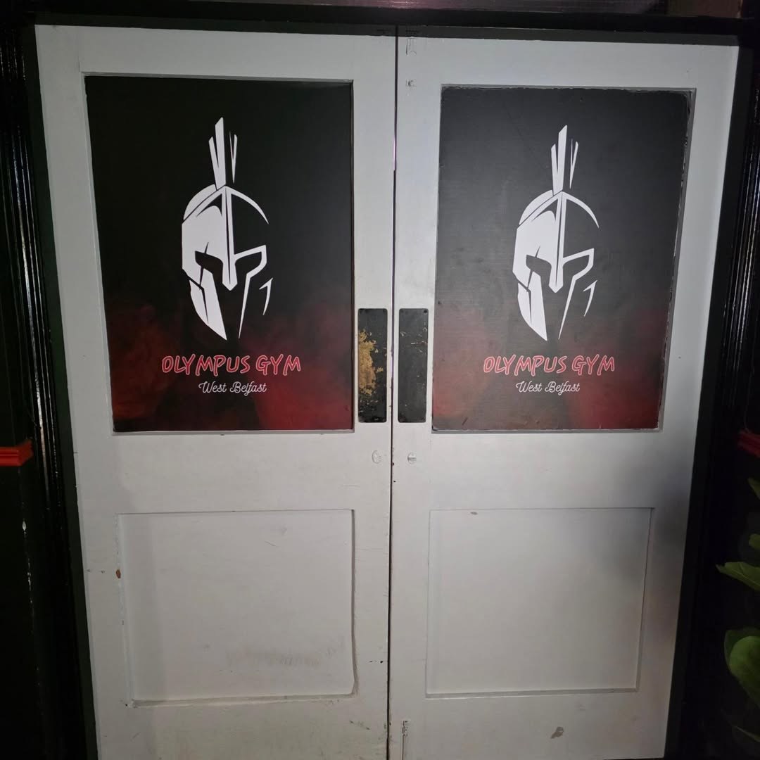White double doors with red Spartan helmet graphics at the gym entrance